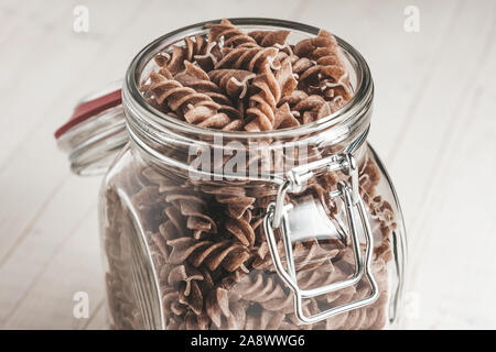 Close-up of an Italian Pasta dans un bocal en verre sur fond blanc planches en bois Banque D'Images