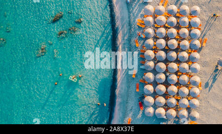 De haut en bas Vue aérienne de la plage magnifique avec parasols et la mer turquoise au coucher du soleil. Mer Méditerranée, Crète, Grèce. Banque D'Images