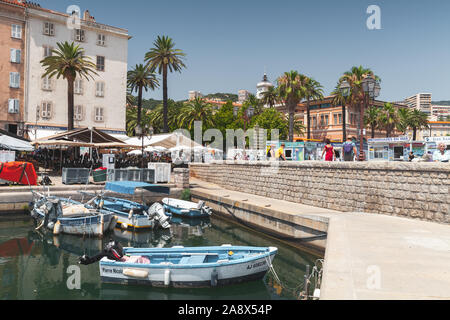 Ajaccio, France - le 6 juillet 2015 : les bateaux de pêche sont amarrés dans le vieux port d'Ajaccio, la capitale de l'île de Corse. Les gens ordinaires à pied la rue Banque D'Images