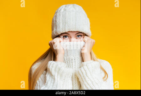 Blonde girl in winter hat couvrant son visage d'homme Banque D'Images