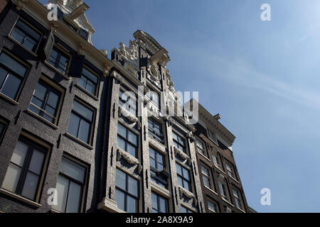 Vue de dessous, historiques et traditionnels de bâtiments typiques montrant un style architectural Néerlandais à Amsterdam. Il s'agit d'une journée ensoleillée. Banque D'Images