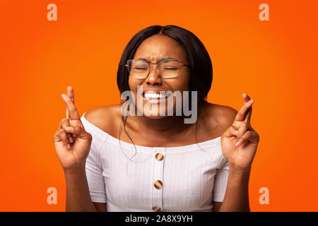 Black Girl gardant les doigts croisés pour Chance Standing, Studio Shot Banque D'Images