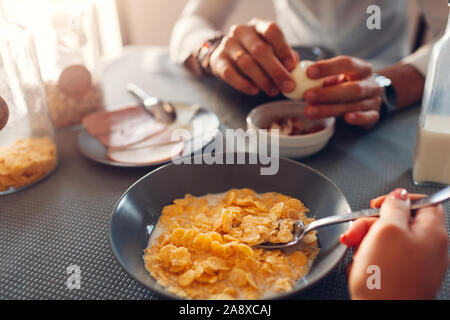 Cornflake Céréales avec lait petit-déjeuner. Couple Famille une alimentation saine. Man peeling d'œufs. Banque D'Images