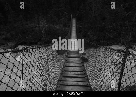 Image en noir et blanc d'un pont de bois suspendu Rivière Glacier. Banque D'Images