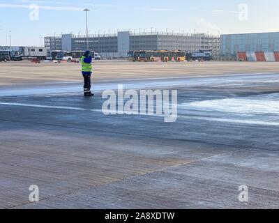 Londres, Angleterre - 9 novembre, 2019 : travail de l'opérateur de l'aéroport à l'aéroport de Stansted debout derrière un avion de Ryanair dans une froide journée ensoleillée Banque D'Images