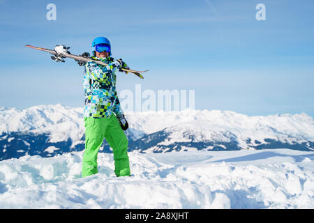 Photo pleine longueur de l'homme en casque avec snowboard debout à snow resort sur journée d'hiver Banque D'Images