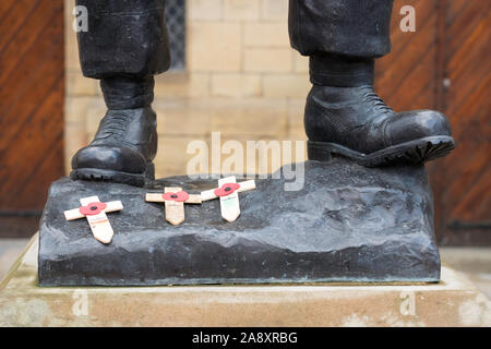 Croix de bois de coquelicots jeté aux pieds de la statue commémorative de l'infanterie légère de Durham pendant le jour de l'Armistice, le centre-ville de Durham, England, UK Banque D'Images