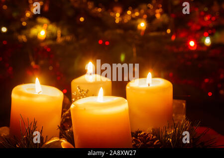 Couronne de l'avent avec 4 bougies allumées avec décoration de fête de Noël Banque D'Images