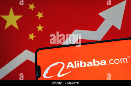 Logo d'Alibaba sur smartphone et écran floue avec drapeau de la Chine avec la flèche à l'arrière-plan. Photo conceptuelle. Banque D'Images