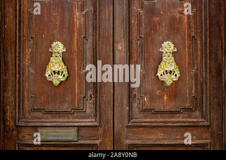 La texture d'une vieille porte en bois en bois avec poignées en métal inhabituel sur l'île de Malte Banque D'Images