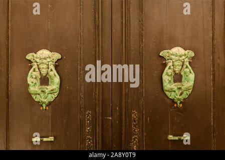 La texture d'une vieille porte en bois en bois avec poignées en métal inhabituel sur l'île de Malte Banque D'Images