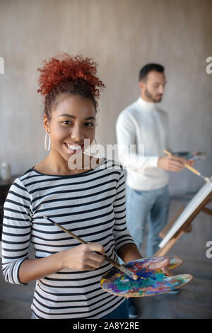 Artiste attrayants portant chemise rayée gouache de mélange Banque D'Images