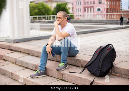 Pensez à quelque chose et l'homme assis dans les escaliers Banque D'Images