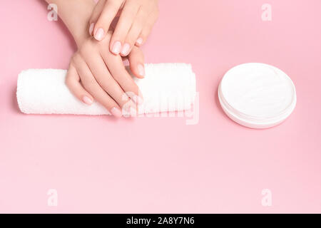 Creative Image de femme avec ses mains hydratante crème cosmétique avec copie espace sur fond rose de style minimaliste. Vue d'en haut. Spa et beauté Banque D'Images