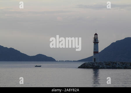 Seascape au coucher du soleil. Le phare sur la côte. Ville balnéaire de Turgutreis et de spectaculaires couchers de soleil Banque D'Images