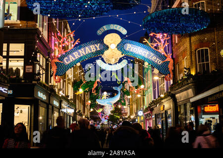 Carnaby Street 2019 Thème : Un océan de lumières de Noël Décoration Sealife fabriqués à partir de matériaux recyclés. Les couleurs de l'image éclairée le soir, avec foule Banque D'Images