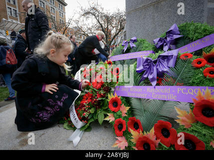 Vancouver, Canada. 11Th Nov, 2019. Les axes d'un enfant un coquelicot sur une couronne devant le cénotaphe au cours de la cérémonie du Jour du Souvenir à la place de la Victoire à Vancouver, Canada, le 11 novembre 2019. Des milliers de personnes ont participé à la cérémonie du Jour du Souvenir et défilé pour honorer les anciens combattants du Canada à Vancouver lundi. Credit : Liang Sen/Xinhua/Alamy Live News Banque D'Images