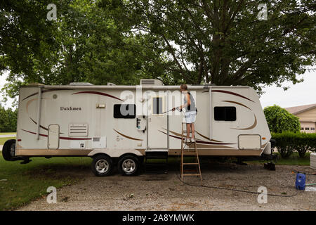 Un homme se lave pression Dutchmen camping-sur une chaude journée d'été dans le nord-est de l'Indiana. Banque D'Images