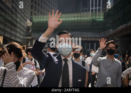 Un homme fait un geste sur les 5 cours d'une marche.Des milliers d'employés de bureau et des manifestants masqués se heurtent à la police dans l'un des plus violents jours pour le pôle financier depuis le début des manifestations il y a cinq mois, un agent de police ont tiré sur un manifestant masqué et un autre homme a été aspergé d'essence et mis le feu. En dépit de la controversée LOI SUR L'extradition qui a suscité les protestations d'être formellement retirée, les manifestants continuent de demander aux Chef de la carrie Lam pour répondre à leurs demandes restantes qui inclut le suffrage universel, une enquête indépendante en brut de la police Banque D'Images