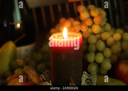 Maison d'automne encore la chaleur de la vie. Bougie marron douce lumière dans le centre avec des raisins frais, des pommes, des poires et du vin avec guitare Banque D'Images