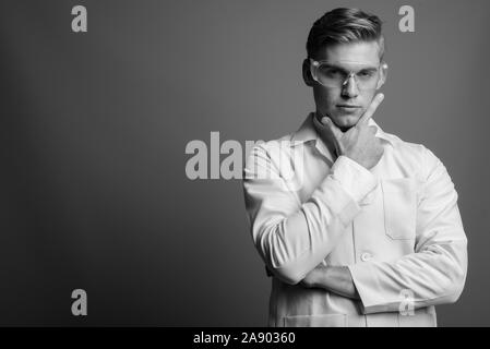 Portrait de jeune homme séduisant médecin comme chercheur scientifique en noir et blanc Banque D'Images