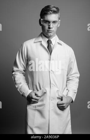 Portrait de jeune homme séduisant médecin comme chercheur scientifique en noir et blanc Banque D'Images