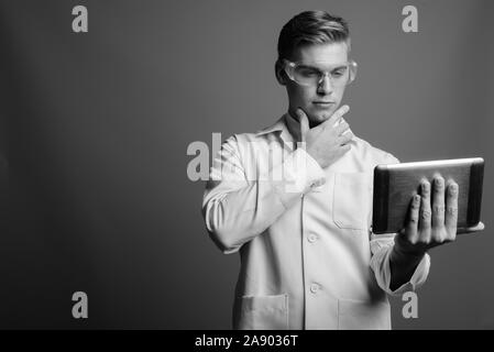 Portrait de jeune homme séduisant médecin comme chercheur scientifique en noir et blanc Banque D'Images