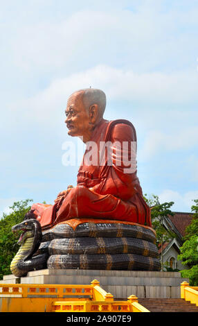 Une sculpture du moine Luang Pu Thuat assis jambes croisées sur un serpent au Wat Mahathat Wachira Monkol Ao Luek Asie Thaïlande Banque D'Images