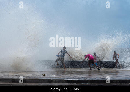 Les enfants de la rue appréciant les vagues qui en face,et Worli Mumbai Maharashtra,Inde, Banque D'Images