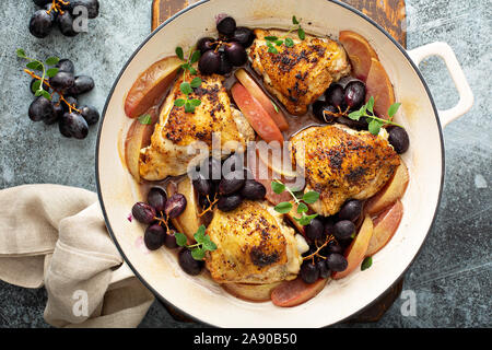Haut de cuisses de poulet rôti aux raisins et pommes, recette dîner d'automne Banque D'Images
