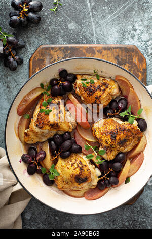 Haut de cuisses de poulet rôti aux raisins et pommes, recette dîner d'automne Banque D'Images