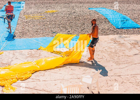 Nice, Provence / France - 29 septembre 2018 : Les hommes exposent un parachute humide après le séchage de la mer sur la plage Banque D'Images