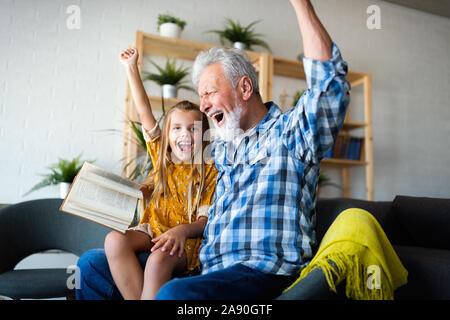 Grand-père barbu et son petit-fils ont du plaisir de lire un livre ensemble Banque D'Images