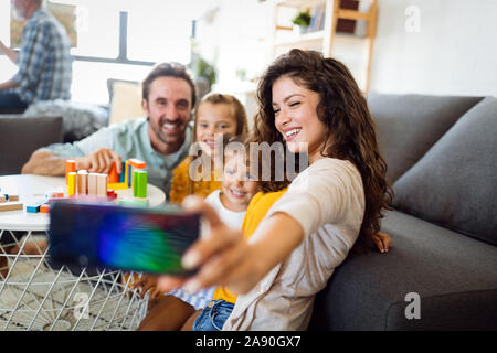 Heureux jeune famille prendre un autoportrait avec smart phone. Banque D'Images