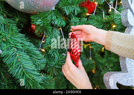 Woman's Hands la décoration ornement sur l'arbre de Noël Banque D'Images