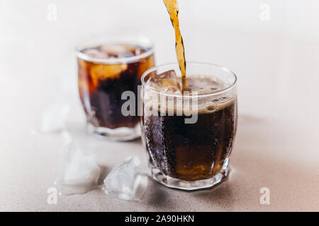 Cola Barman verse dans des verres avec de la glace - close-up et copy space Banque D'Images