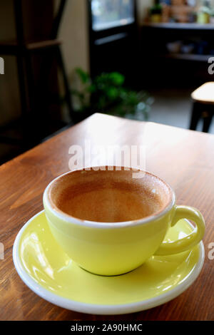 Vertical image d'une tasse vide de fini de boire du café isolé sur table en bois du café Banque D'Images