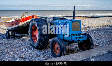 Le tracteur et le bateau de pêche de crabe traditionnels sur l'arrière d'une remorque le tracteur garé sur plage de Cromer Banque D'Images
