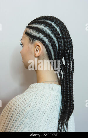 Tissage de cheveux, photo d'une fille, le résultat du travail d'un salon de beauté avant et après, afro boucle close-up sur fond blanc Banque D'Images