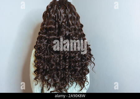 Tissage de cheveux, photo d'une fille, le résultat du travail d'un salon de beauté avant et après, afro boucle close-up sur fond blanc Banque D'Images