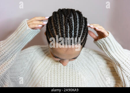 Tissage de cheveux, photo d'une fille, le résultat du travail d'un salon de beauté avant et après, afro boucle close-up sur fond blanc Banque D'Images