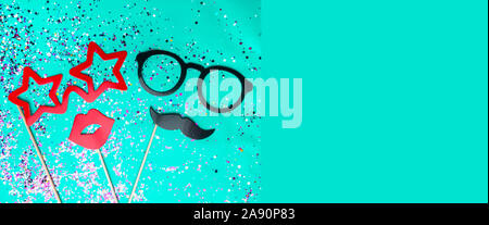 Composition festive avec moustache, lunettes, bouche rouge lèvres accessoires photo et confettis colorés sur fond de menthe verte concept, hommes et femmes, de copie Banque D'Images