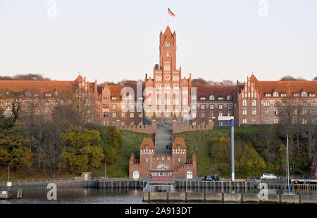 Flensburg, Allemagne. 29 Oct, 2019. Vue de l'école navale dans le district de Flensbourg Mürwik. Sur le modèle du style gothique en brique du nord de l'Allemagne, il a été au centre de formation pour les officiers de la marine allemande depuis 1910. Avec ses plus de 200 m de long de l'eau et sa tour haute de 60 m environ, il domine la rive sud de la fjord de Flensburg. Crédit : Carsten Rehder/dpa/Alamy Live News Banque D'Images