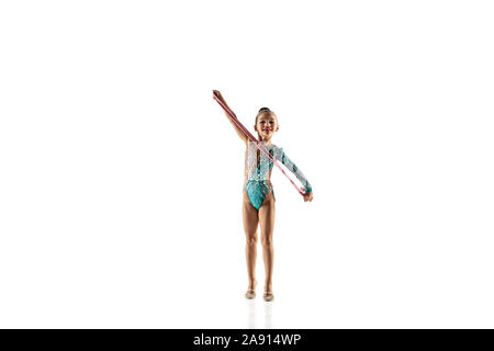 Petite fille souple isolé sur fond blanc studio. Peu de modèle féminin comme un artiste en gymnastique rythmique justaucorps lumineux. La grâce dans le mouvement, l'action et le sport. Faire des exercices avec la corde. Banque D'Images