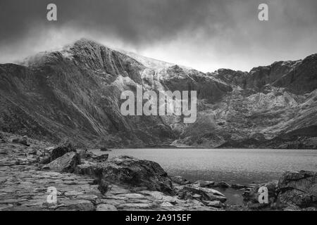 Superbe paysage d'hiver spectaculaire image de Llyn Idwal et sommets de montagnes de Snowdonia en Glyders en noir et blanc Banque D'Images