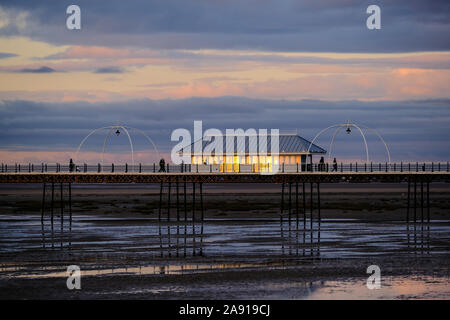 Le soleil qui se reflète dans les fenêtres d'un logement sur la jetée de Southport Banque D'Images