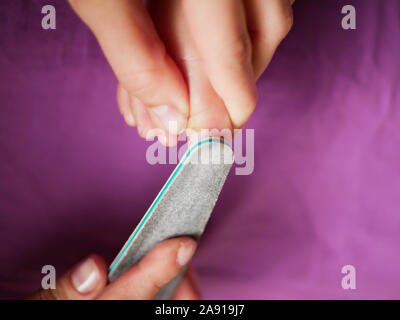 Maman prend soin de l'ongles babys. Close-up. Irrégularités scies avec une lime à ongles d'un enfant nouveau-né. Maman et bébé de soins. Prendre soin d'un enfant les ongles. Banque D'Images