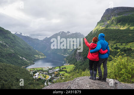 Vue sur le village touristique à Geiranger, Norvège. Les touristes sont à un point panoramique et regarder les montagnes et le Geirangerfjord Banque D'Images