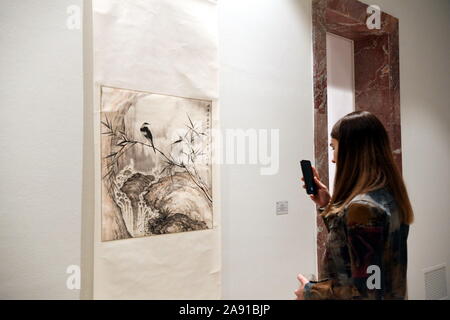 (191112) -- Tirana, 12 novembre 2019 (Xinhua) -- une femme visites une exposition pour marquer le 70e anniversaire de l'établissement de relations diplomatiques entre la Chine et l'Albanie au centre de l'ouverture et le dialogue (COD) du bureau du Premier Ministre de l'Albanie à Tirana, Albanie le 11 novembre 2019. L'exposition, organisée par le COD en coopération avec l'ambassade de Chine à l'Albanie, est intitulée "Au-delà des souvenirs. L'exposition a rassemblé une collection de timbres commémoratifs sur Chine émis par la poste albanaise de 1968 à 2009, ainsi que des œuvres traditionnelles chinoises de la ville de Nanjing. Banque D'Images