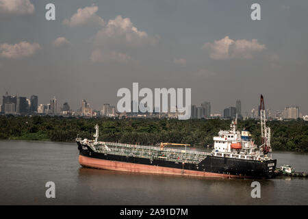 Bangkok, Thaïlande - 24 Oct 2019 : un cargo garé en plein milieu de la rivière et en face d'un arbre vert par la rivière Chao Phraya. Banque D'Images